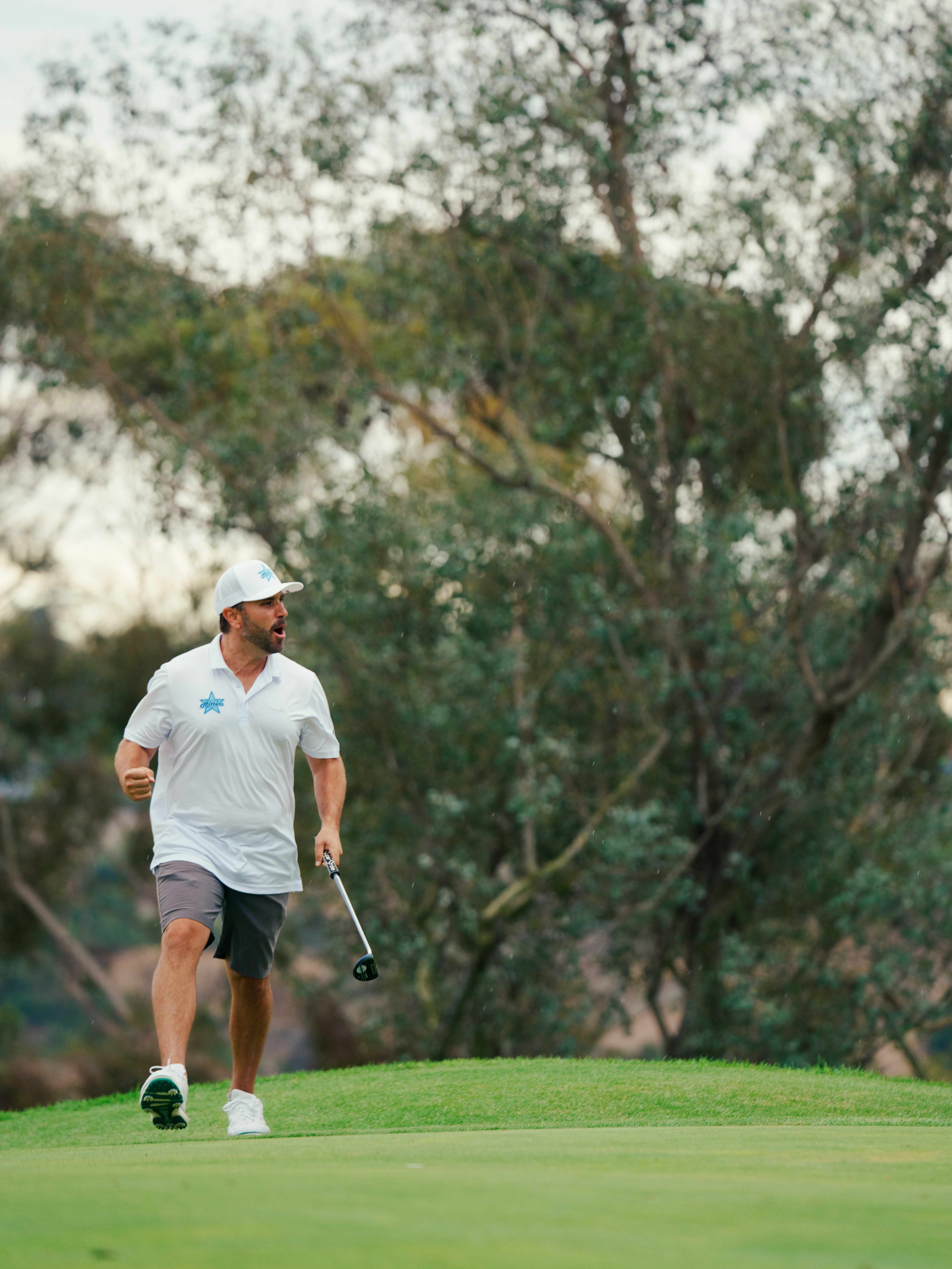 A Hollywood Hitters player fist pumps walking off the green