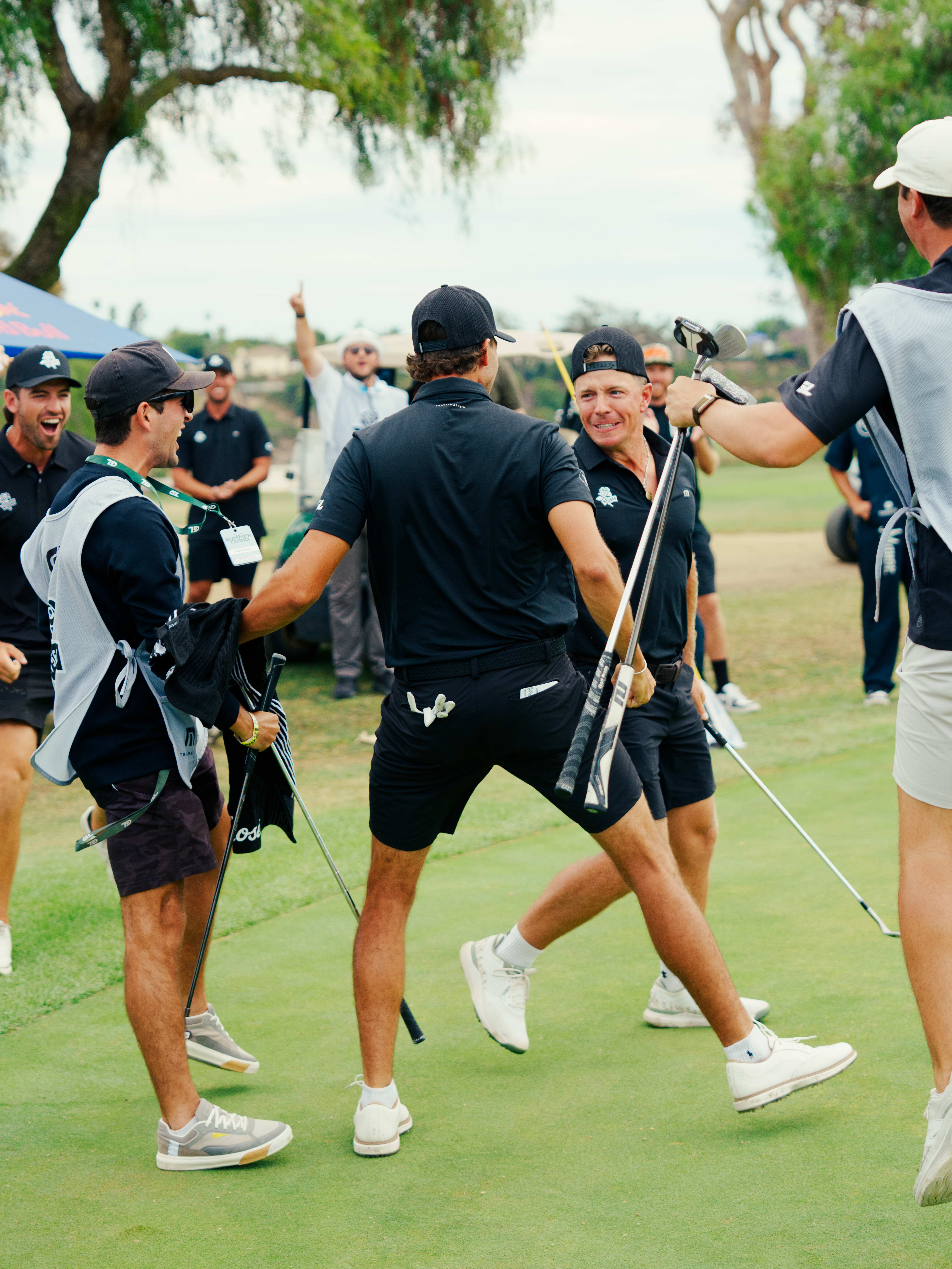 Los Angeles Roses celebrate on the green, crowd behind them